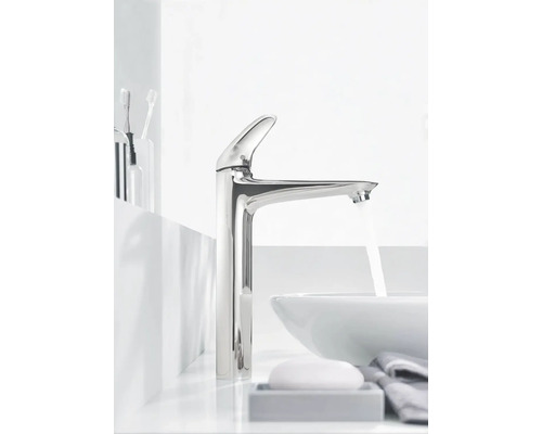 Moderní koupelna s lesklou vodovodní baterií, umyvadlem a koupelnovými doplňky.