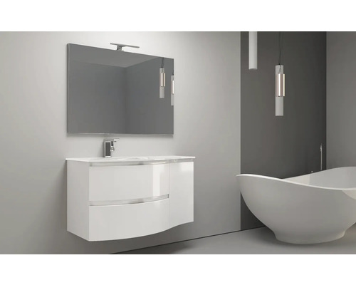 Koupelna s umyvadlovou skříňkou, zrcadlem, lampou a vanou.