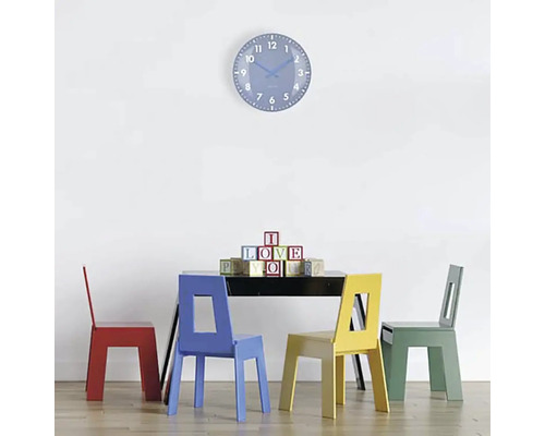 Scéna se stolem, čtyřmi židlemi a nástěnnými hodinami