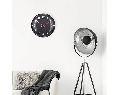 Obývací pokoj s nástěnnými hodinami, stojací lampou a pohovkou