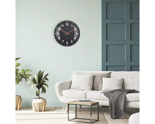 Obývací pokoj s nástěnnými hodinami, pohovkou a konferenčním stolkem