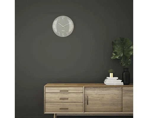 Obývací pokoj s nástěnnými hodinami a dřevěnou komodou