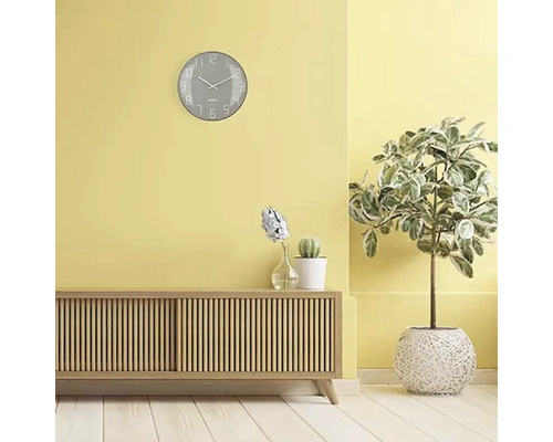 Obývací pokoj s příborníkem, pokojovými rostlinami a nástěnnými hodinami