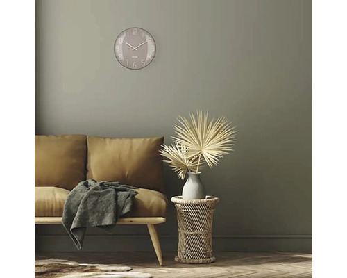 Obývací pokoj s pohovkou, odkládacím stolkem, dekorací a kulatými nástěnnými hodinami