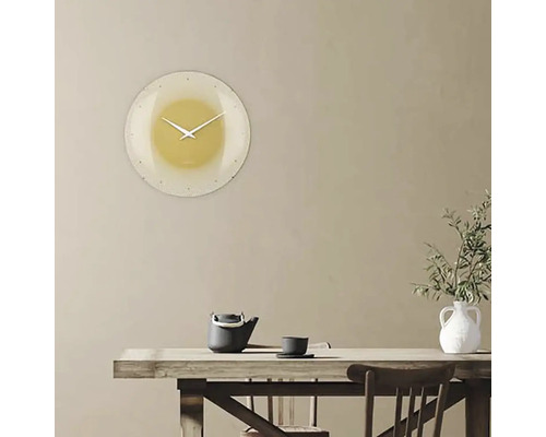 Nástěnné hodiny v obývacím pokoji nad stolem s čajovou konvicí a vázou