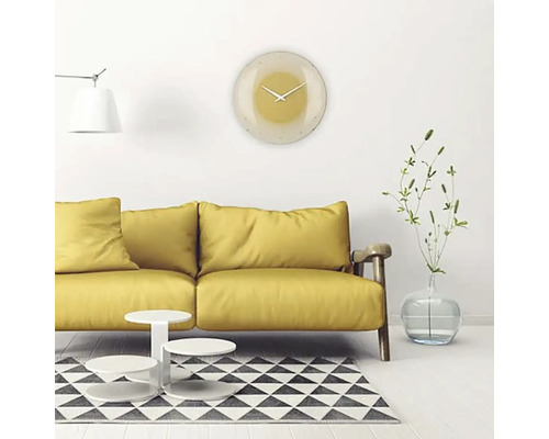 Obývací pokoj se žlutou pohovkou, konferenčním stolkem, kobercem a kulatými nástěnnými hodinami