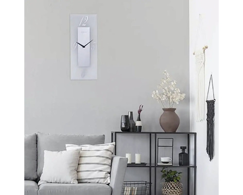 Obývací pokoj s pohovkou, regálem a obdélníkovými nástěnnými hodinami s číslicemi