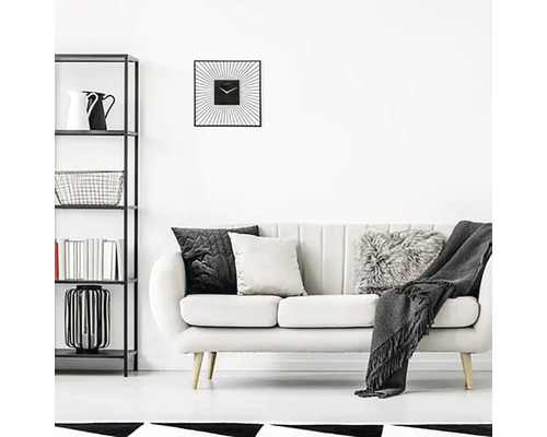 Obývací pokoj s policí, pohovkou, polštáři a čtvercovými nástěnnými hodinami