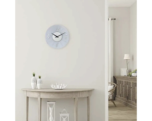 Světlý interiér s nástěnnými hodinami, komodou a stolem