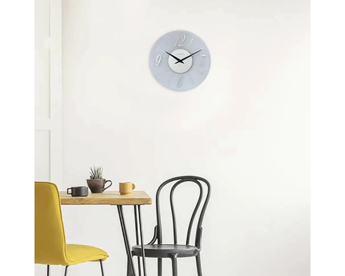 Scéna s nástěnnými hodinami nad jídelním stolem se židlemi