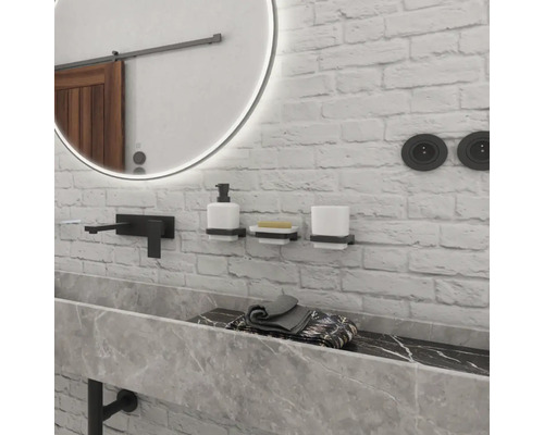 Moderní koupelna se zrcadlem, umyvadlem, baterií a doplňky na cihlové zdi