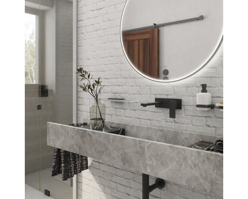 Moderní koupelna s umyvadlem z mramoru, kulatým zrcadlem a baterií