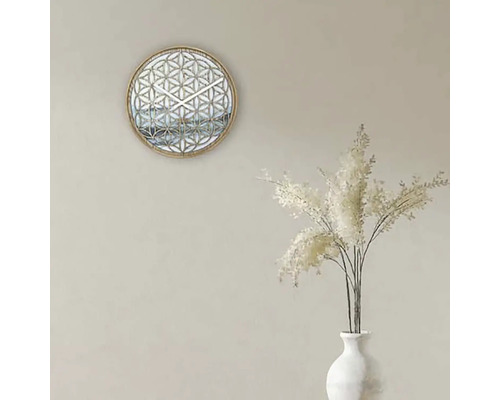 Dekorativní nástěnné hodiny s geometrickým vzorem a bílé okrasné trávy ve váze