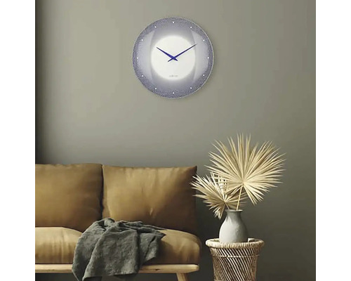 Obývací pokoj s pohovkou, odkládacím stolkem s dekorací a kulatými nástěnnými hodinami