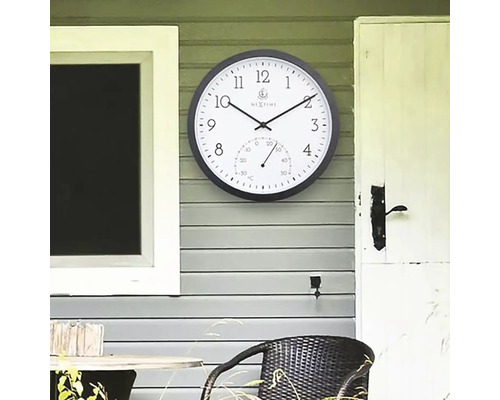 Analogové nástěnné hodiny s teploměrem pro venkovní použití na stěně domu