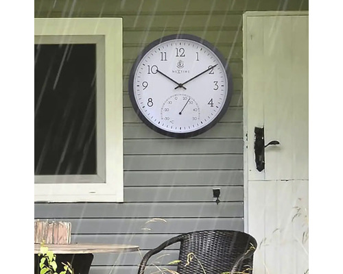 Venkovní fotografie nástěnných hodin s teploměrem na stěně domu