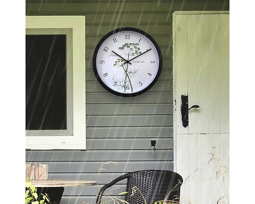 Nástěnné hodiny s motivem bylin na stěně domu