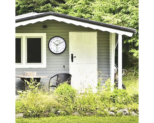 Zahradní domek s hodinami, stolem a židlí před stromy