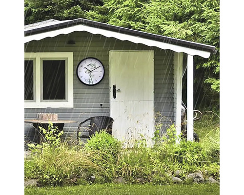 Zahradní domek se stolem, židlí a hodinami v dešti
