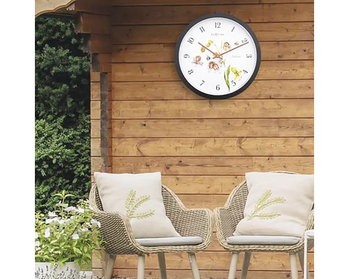 Zahradní scéna s nástěnnými hodinami, židlemi a polštáři