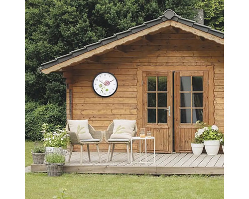 Dřevěný zahradní domek s nástěnnými hodinami a posezením na terase