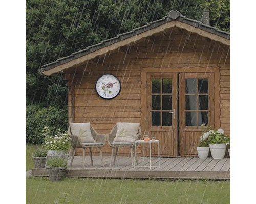 Zahradní domek s nástěnnými hodinami v dešti, židlemi a stolem