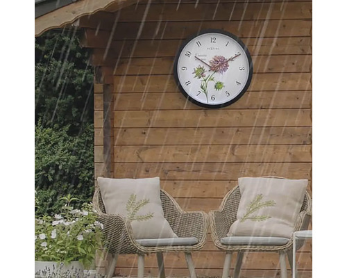Zahradní domek s venkovními hodinami a dvěma ratanovými křesly s polštáři