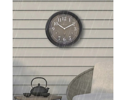 Analogové venkovní hodiny s ukazatelem teploměru a vlhkoměru na stěně domu