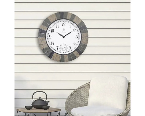 Venkovní hodiny s teploměrem na stěně nad židlí a stolem.