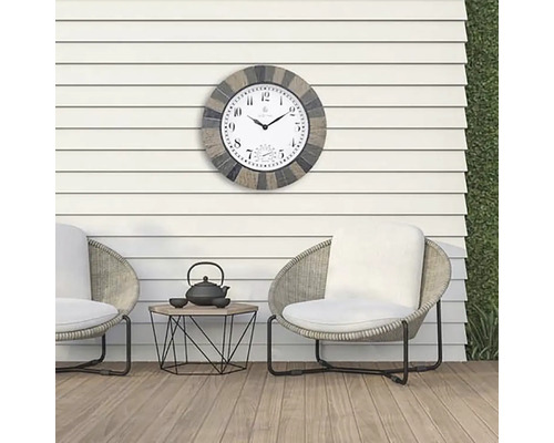 Venkovní prostor se dvěma židlemi, stolem a nástěnnými hodinami