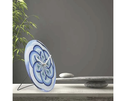 Dekorativní stolní hodiny s modrým květinovým vzorem na stole