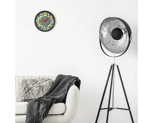 Obývací pokoj s pohovkou, stojací lampou a nástěnnými hodinami