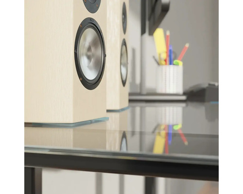 Detailní záběr dvou světlých reproduktorů na skleněném stole