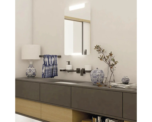 Světlá koupelna s umyvadlem, zrcadlem, lampou a doplňky