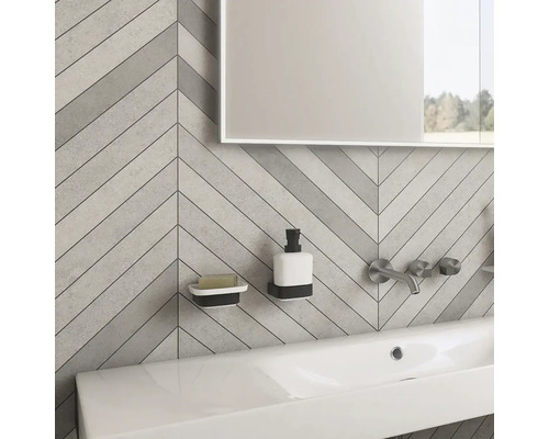 Koupelna s umyvadlem, vodovodní baterií, zrcadlem, dávkovačem mýdla a miskou na mýdlo před stěnou se vzorem rybí kosti