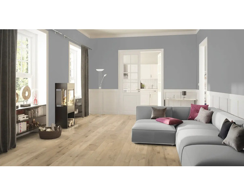 Obývací pokoj s pohovkou, kamny a světlou laminátovou podlahou.