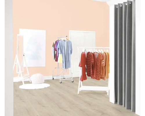 Světlá místnost se stojany na šaty a závěsem jako převlékací kabina