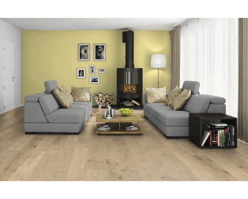 Světlý obývací pokoj s šedými pohovkami, krbem a dřevěnou podlahou