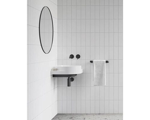 Koupelna s umyvadlem, zrcadlem, držákem na ručníky a bílými obklady