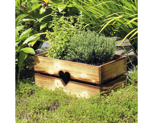 Dřevěný truhlík na květiny s motivem srdce v zahradě