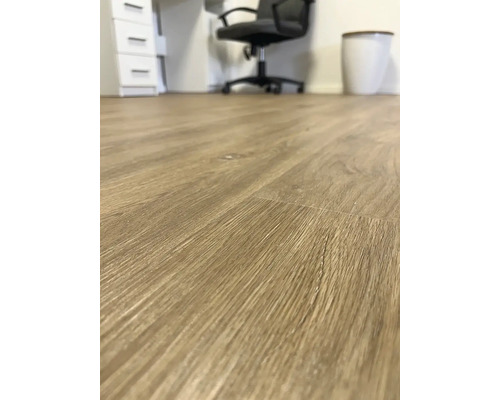 Detail světle hnědé laminátové podlahy v kancelářských prostorách.