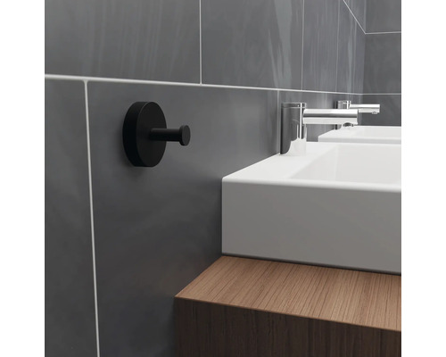 Koupelnová scéna s umyvadlem, armaturami a černým hákem