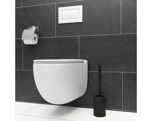 Závěsný záchod s držákem toaletního papíru a štětkou na toaletu před šedou stěnou