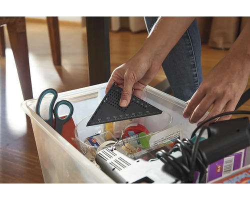 Osoba vkládá úhloměr do úložného boxu s nářadím.