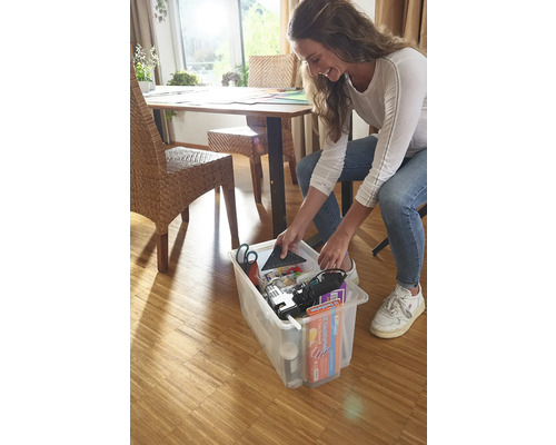 Žena ukládá nářadí a materiály do průhledného úložného boxu.