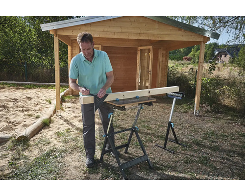 Muž, úhelník, tužka a pracovní stůl na zahradě