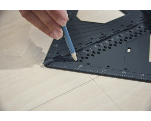 Osoba používá úhelník a tužku k rýsování na dřevo.