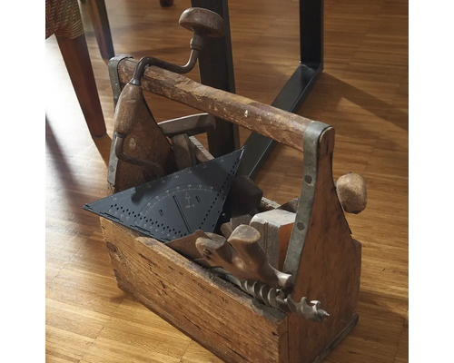 Dřevěná bedna na nářadí plná nářadí, jako je úhloměr, vrták a kladivo