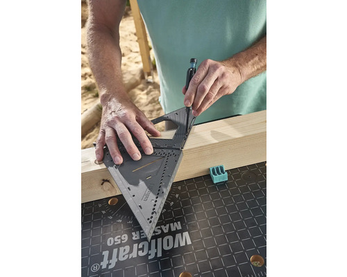 Osoba používá úhelník k označení dřevěné desky.