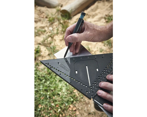 Ruka kreslí čáru tesařskou tužkou s úhloměrem na plech.